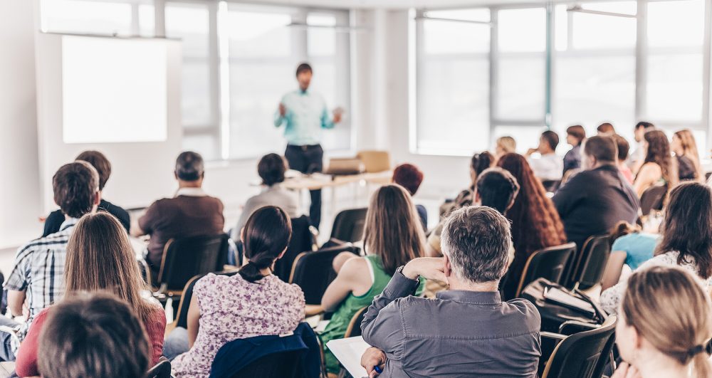 Speaker giving presentation on business conference lecture.
